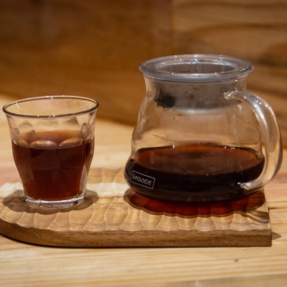Fresh pour-over coffee served in a glass server and cup at Overflow Coffee Lucknow