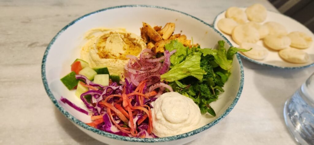  Chicken shawarma bowl with hummus, garlic toum, pickled onions, red cabbage slaw, summer salad and mini pita bread at Overflow Coffee in Golf City Lucknow